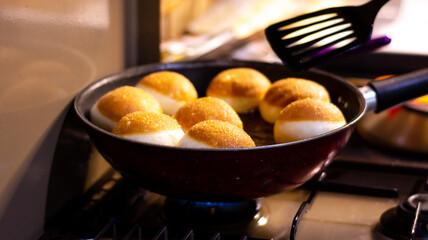 Fried dougnut with beautiful dark brown color in the pan, ready to serve