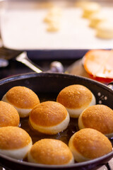 Fried dougnut with beautiful dark brown color in the pan, ready to serve