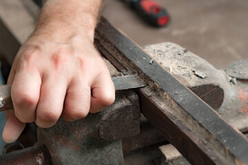 Male carpenter working on old wood in a retro vintage style.