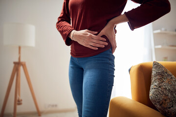 Woman with strong hip pain at home. - obrazy, fototapety, plakaty
