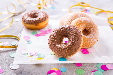Donuts with streamers and confetti. Donuts for carnival and party.