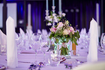 Hochzeit Location mit eingedeckten Tischen und weißen Tischdecken 
