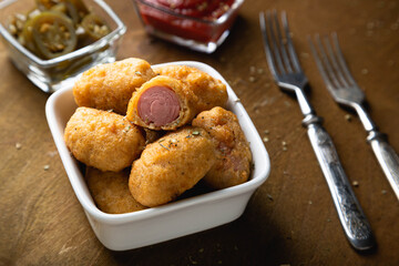 Mini corn dog with ketchup and jalapeno pepper