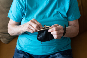 Hands of old person, senior holds wallet with money. Hands older woman calculate her small money. real problem of pension. economy of one person in family.