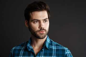 Brunette handsome unshaven guy posing and looking aside