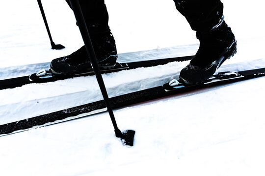 Cross-country skiing boots, poles and skis, close up image.