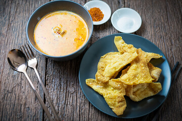 Crispy Wonton Noodles in hot and spicy Soup with fish balls, Crispy pork, and special homemade Soup. Tom Yum Thai noodles soup.