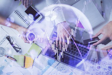 Multi exposure of man's hands typing over computer keyboard and forex graph hologram drawing. Top...