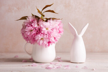 Figurine of Easter bunny and bouquet of pink sakura