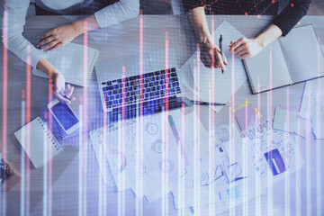 Double exposure of woman hands working on computer and forex graph hologram drawing. Top View....