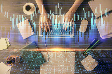 Multi exposure of woman hands working on computer and forex chart hologram drawing. Top View....