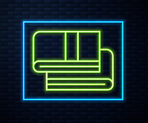 Glowing neon line Towel stack icon isolated on brick wall background. Vector.