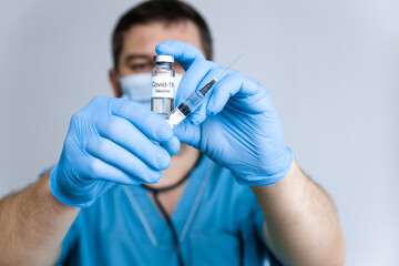 Doctor in rubber gloves holding coronavirus COVID-19 vaccine in vial and syringe. Healthcare And Medical concept. Close up