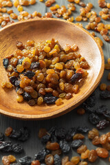 In the center on a wooden table in a plate is a raisin