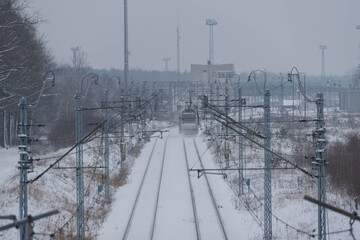 Lokomotywa elektryczna jadąca po torach pokrytych śniegiem. © boguslavus