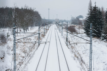 Lokomotywa elektryczna jadąca po torach pokrytych śniegiem. © boguslavus