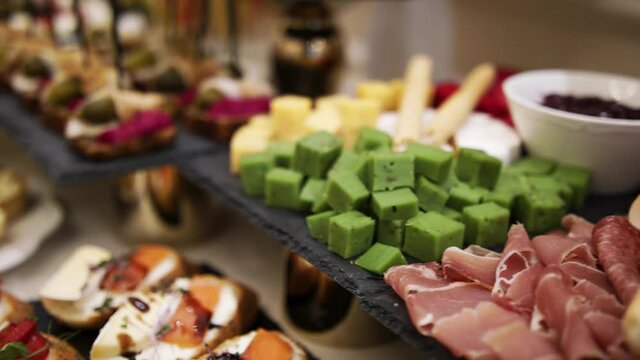 The waiters prepare the table with canapes and appetizers for the event. Close-up