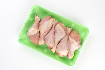 Raw chicken parts in green plastic container
