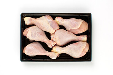 Raw chicken leg quarters in plastic tray