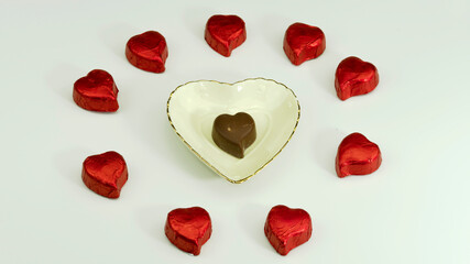 Heart-shaped porcelain plate and red coated heart-shaped chocolates