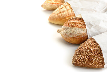 Different types of bread in paper bags on a white background.