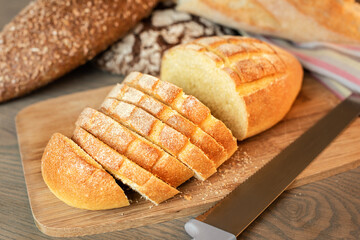 Sliced bread on the table on a background of various breads.