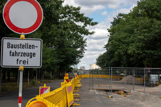 View of a construction site for a new street with traffic signs with the German text "construction sites vehicles free" and a safety fence in Leipzig, Germany a