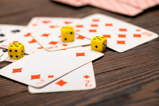 Playing cards and dice on a wooden table.