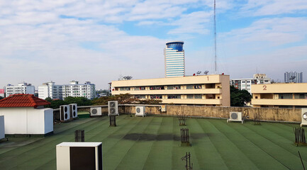 Fototapeta premium Many kind of air compressors installed on rooftop of terrace with height building, telecommunication tower, blue sky and clouds background. Technology and Exterior design.