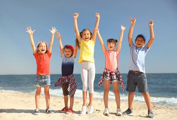 Obraz premium Group of happy children at sea beach on sunny day. Summer camp
