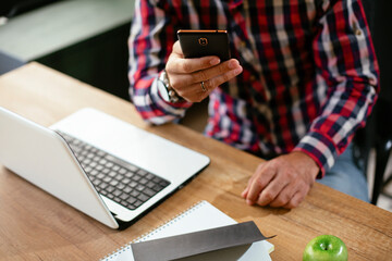 Businessman typing a message. Company manager on his phone sending a message.