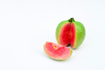One whole guava fruit, a half and a slice with pink flesh isolated on white background