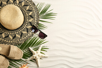 Different beach accessories on sand, flat lay. Space for text