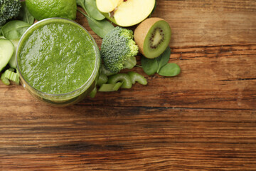 Green juice and fresh ingredients on wooden table, flat lay. Space for text