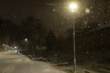 city park on a winter night, beautiful decorative lighting, strong cold snowstorm without people