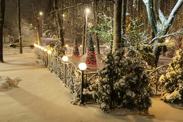 the winter park is decorated with garlands, the beautiful photo zone is covered with snow, the fabulous atmosphere of the night city