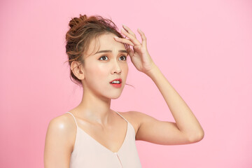 beauty portrait of sad woman touching her skin on pink background