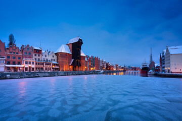 Naklejka premium Medieval port crane in Gdansk at Motlawa river in snowy winter, Poland