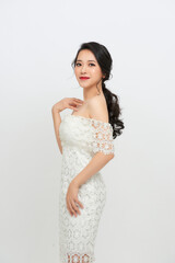 Portrait of a beautiful girl bride in a long lace dress with an elegant hairstyle.