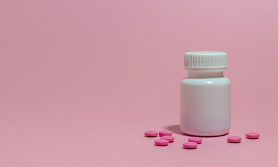 White jar with tablets on a pink background. Health. Medicine.