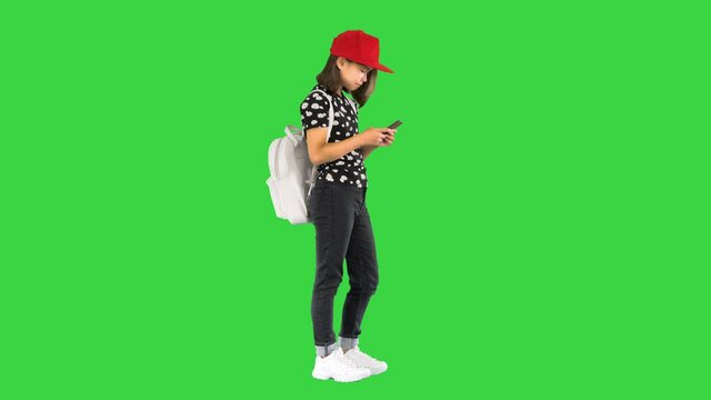 Asian school girl check her email with a mobile phone on a Green Screen, Chroma Key.