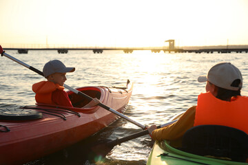 Little children kayaking on river, back view. Summer camp activity