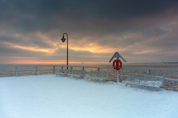 Beautiful wooden pier in Gdynia Orlowo at snowy winter, Baltic Sea. Poland