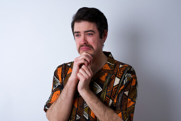 Sad Young caucasian man wearing generic pattern printed shirt desperate and depressed with tears on her eyes suffering pain and depression  in sadness facial expression and emotion concept