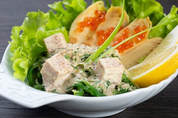 traditional Japanese salad of seaweed, cheese, red caviar and lettuce. Japanese kitchen. salad in a white plate