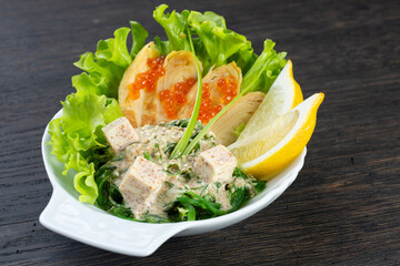 traditional Japanese salad of seaweed, cheese, red caviar and lettuce. Japanese kitchen. salad in a white plate