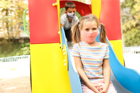 Little Children With Medical Face Masks On Playground During Covid-19 Quarantine