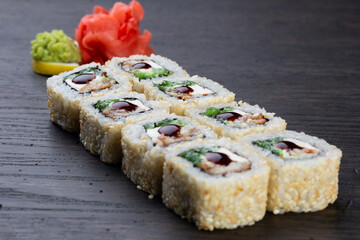 traditional Japanese sushi with eel, soft cheese and white sesame seeds, decorated with a drop of sauce. Japanese kitchen. Japanese restaurant.