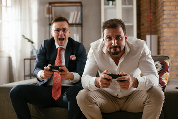 Businessmen playing video games in the office. Colleagues relaxing after meeting.