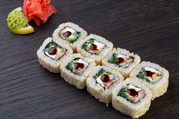 traditional Japanese sushi with eel, soft cheese and white sesame seeds, decorated with a drop of sauce. Japanese kitchen. Japanese restaurant.